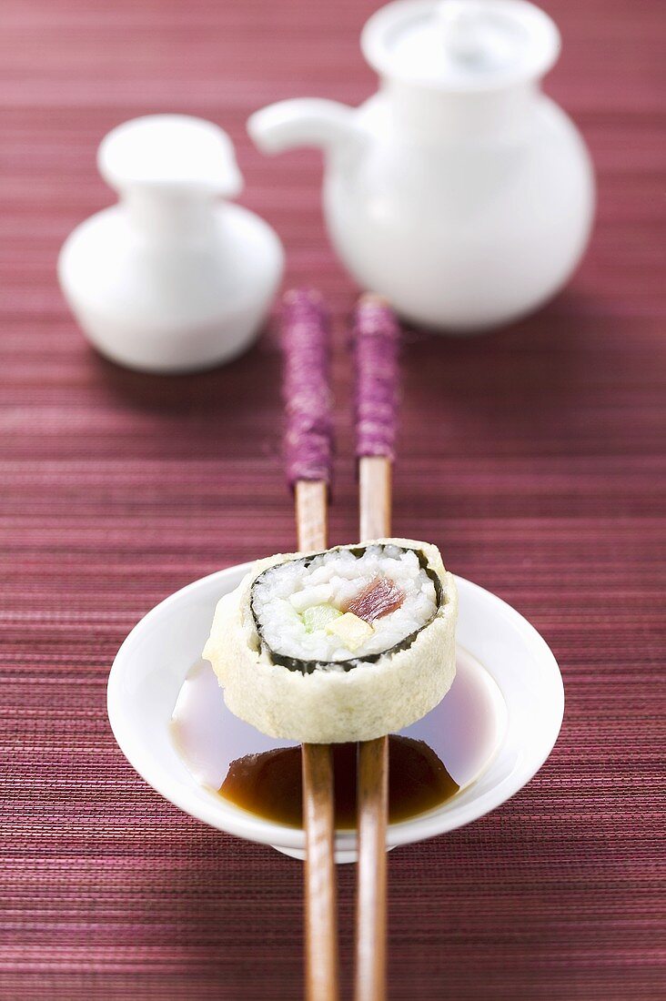 Maki-Sushi mit Thunfisch, Gurke und Avocado über Sojasauce