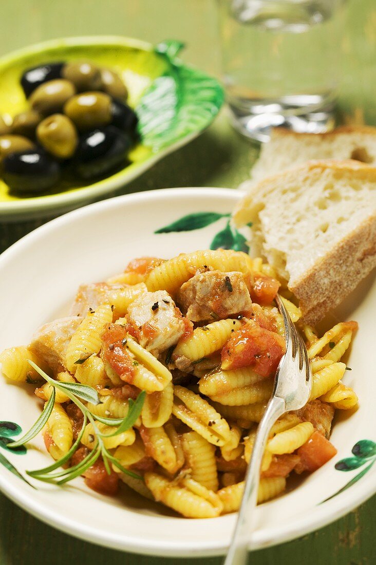 Pasta with meat and tomato sauce, white bread, olives