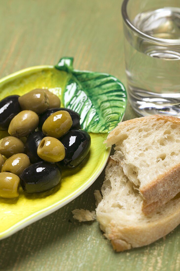 Olives, white bread and glass of water