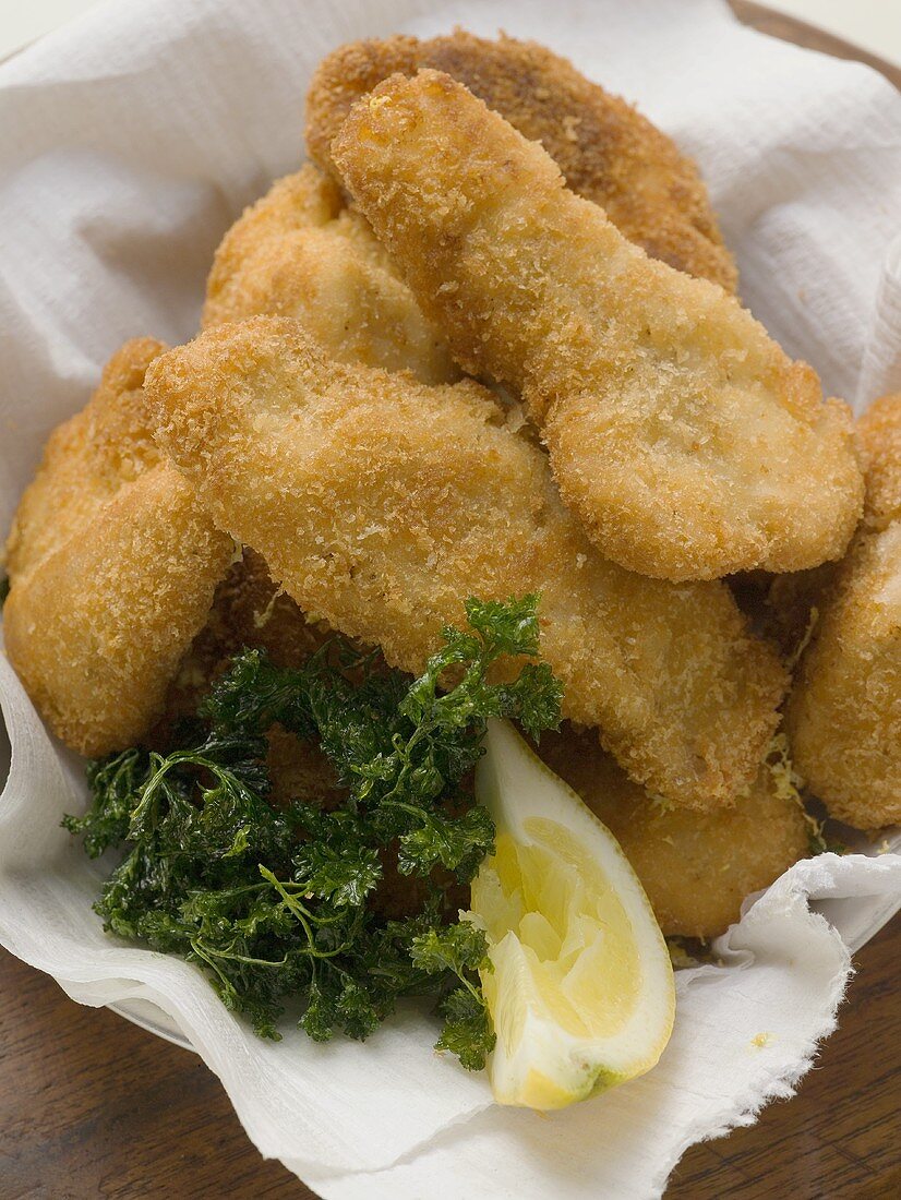 Fish nuggets with lemon wedge and parsley