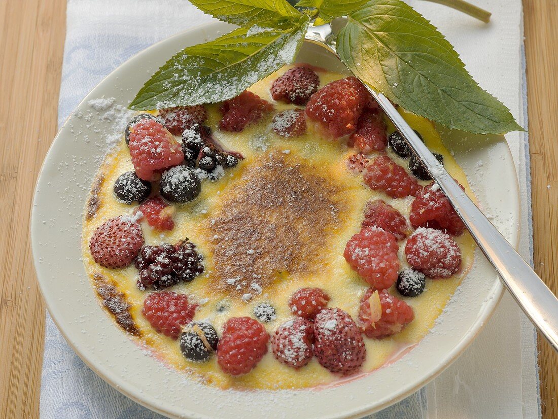 Crème brûlée with berries and icing sugar