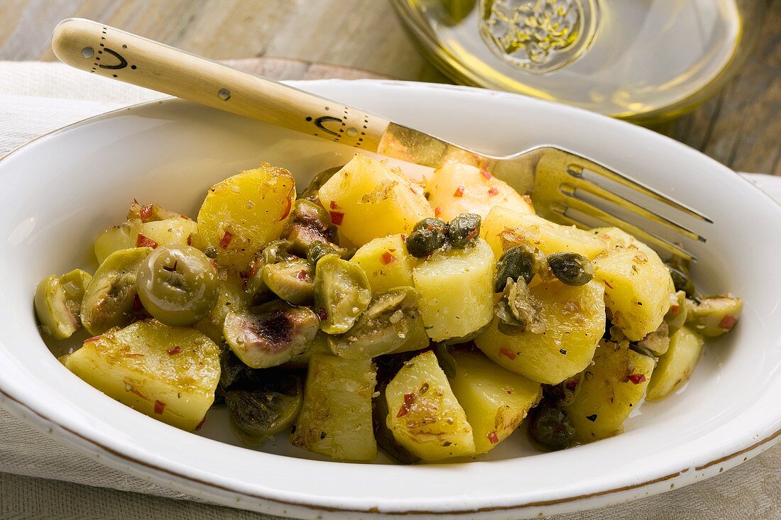 Spicy fried potatoes with olives and capers