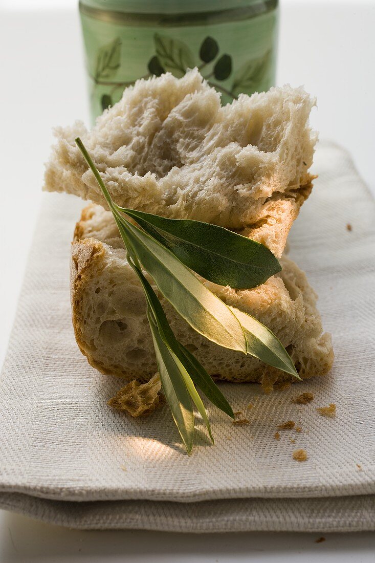 Pieces of white bread on linen cloth with olive sprig