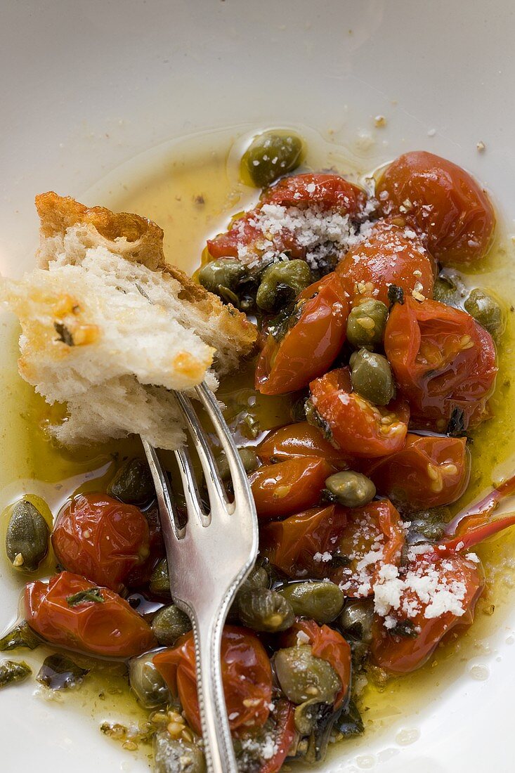 Gebratene Tomaten mit Kapern, Weißbrot auf Gabel