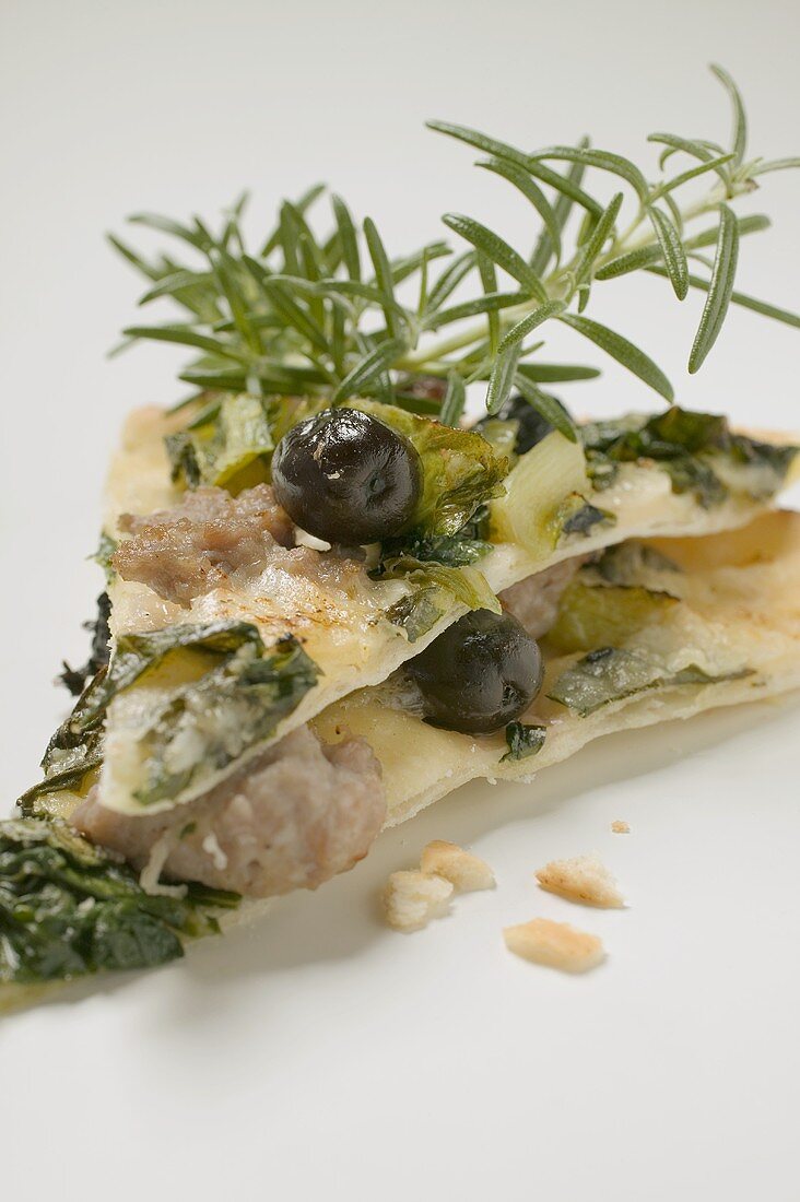 Two slices of pizza with tuna, chard, olives, rosemary