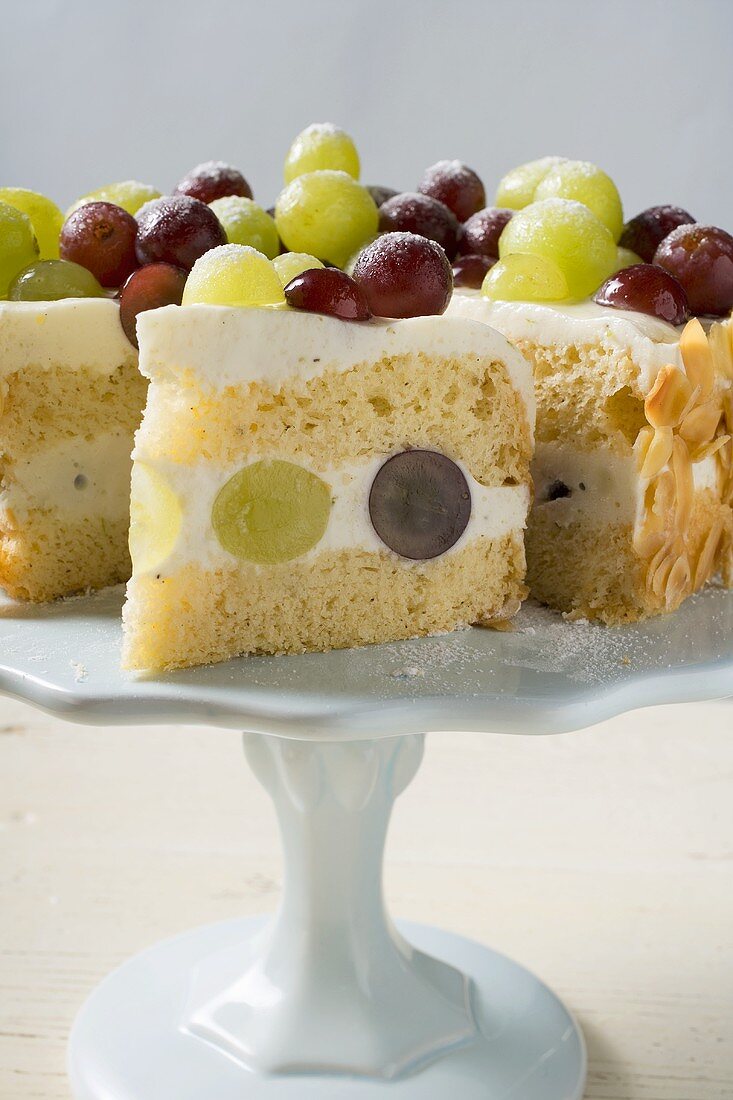 Grape cake, a slice cut, on cake stand
