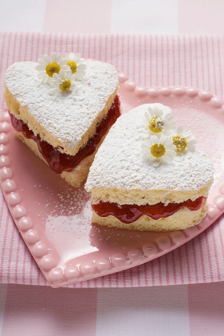 Heart-shaped cakes with jam, icing sugar, daisies