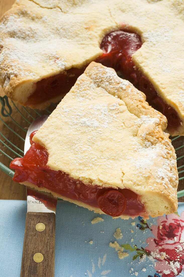 Cherry pie, a slice cut, with slice on knife