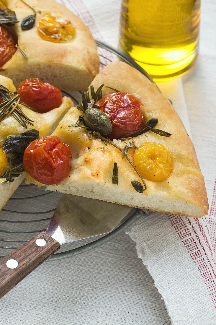 Three slices of pizza with cherry tomatoes, capers & rosemary
