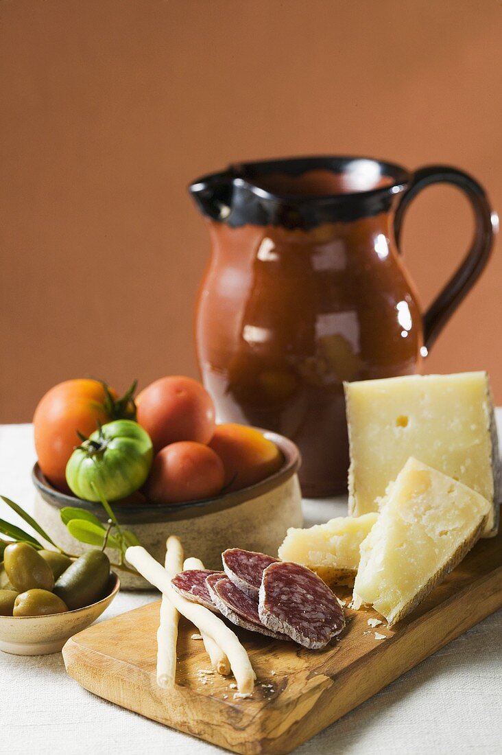 Still life with tomatoes, olives, salami, grissini, Parmesan