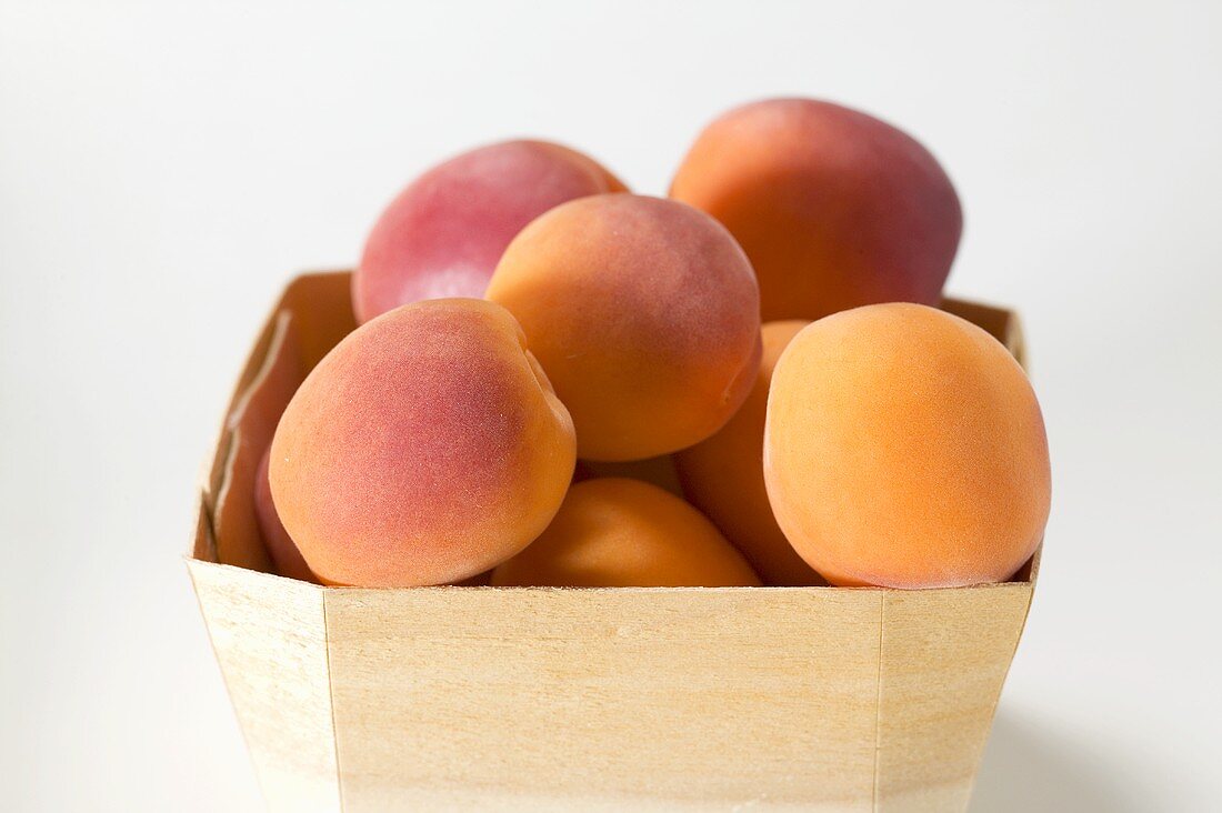 Several apricots in woodchip basket