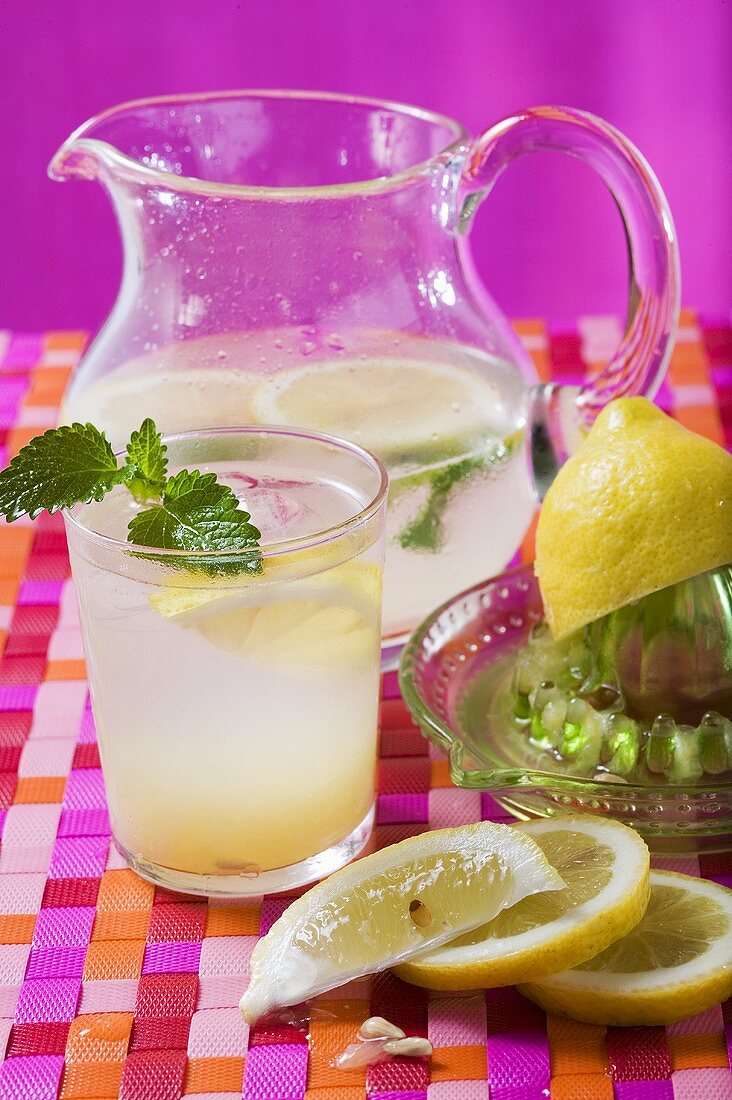 Zitronenlimonade im Glas und Krug