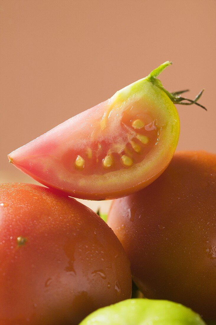 Wedge of tomato on whole tomatoes