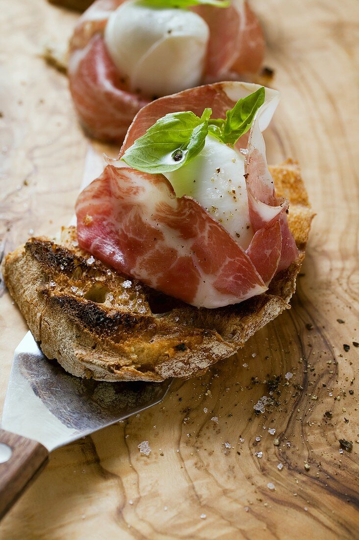 Crostini mit Parmaschinken, Mozzarella und Basilikum