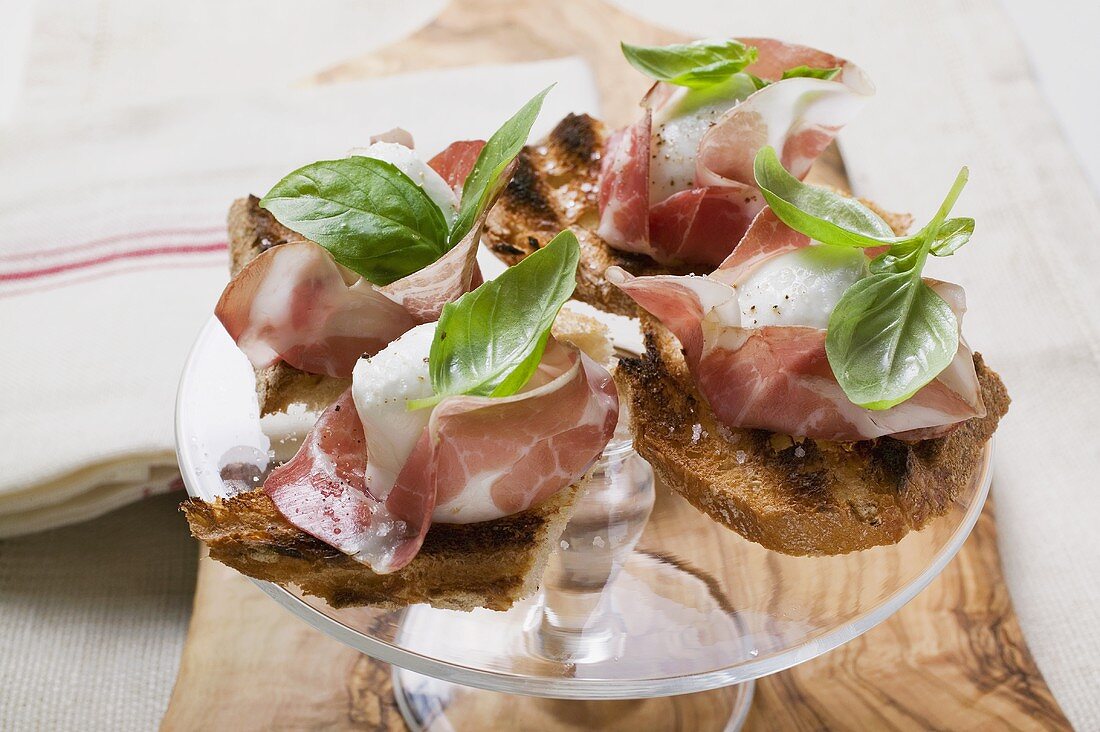 Crostini with Parma ham, mozzarella and basil