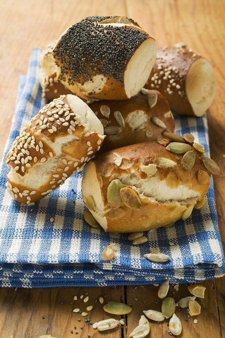 Assorted pretzel rolls on blue and white checked cloth