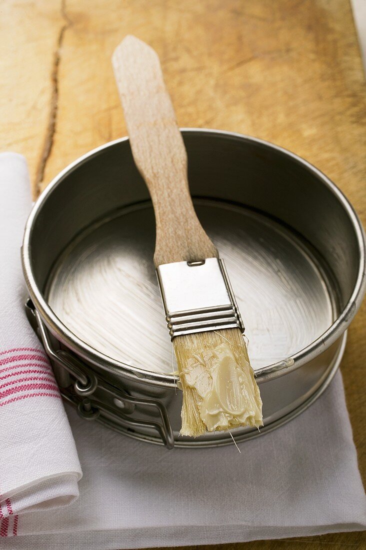 Pastry brush with butter on baking tin