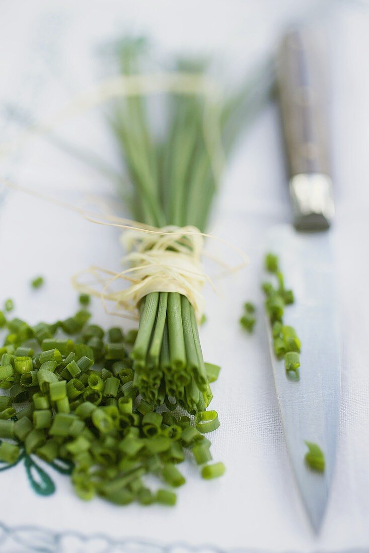 Fresh chives, a bunch and chopped, with knife