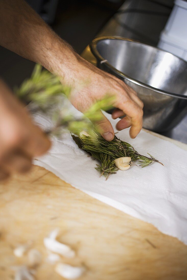 Laying herbs and garlic on kitchen paper