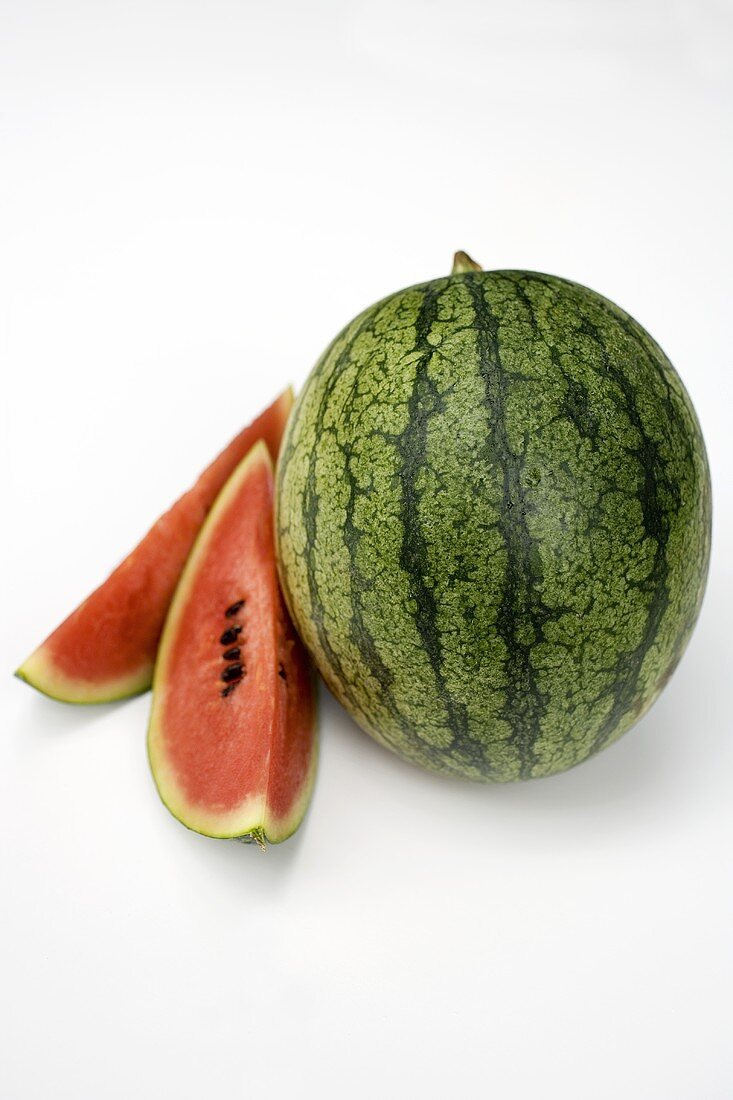 Ganze Wassermelone und zwei Wassermelonenspalten