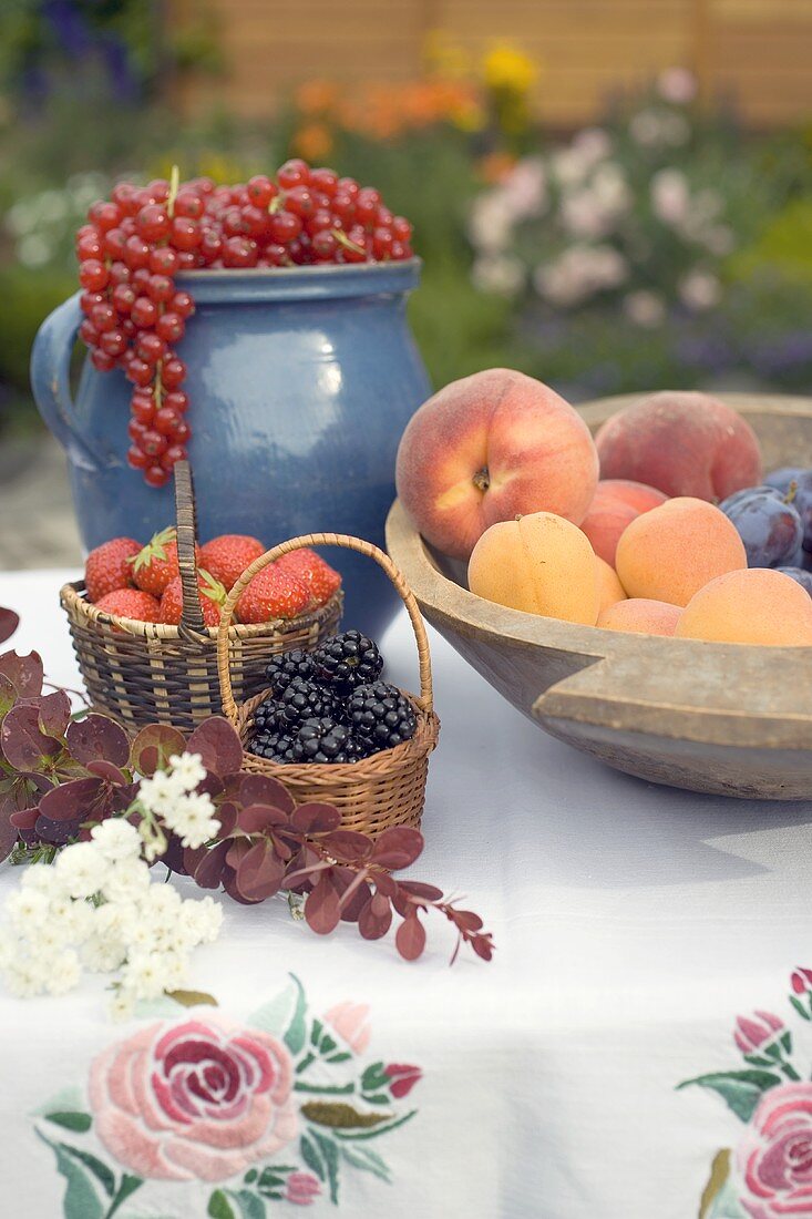 Sommerliches Obststillleben auf Tisch im Garten