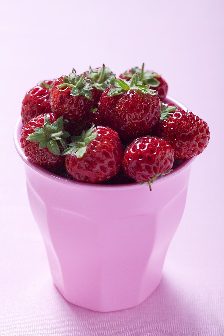 Fresh strawberries in pink beaker