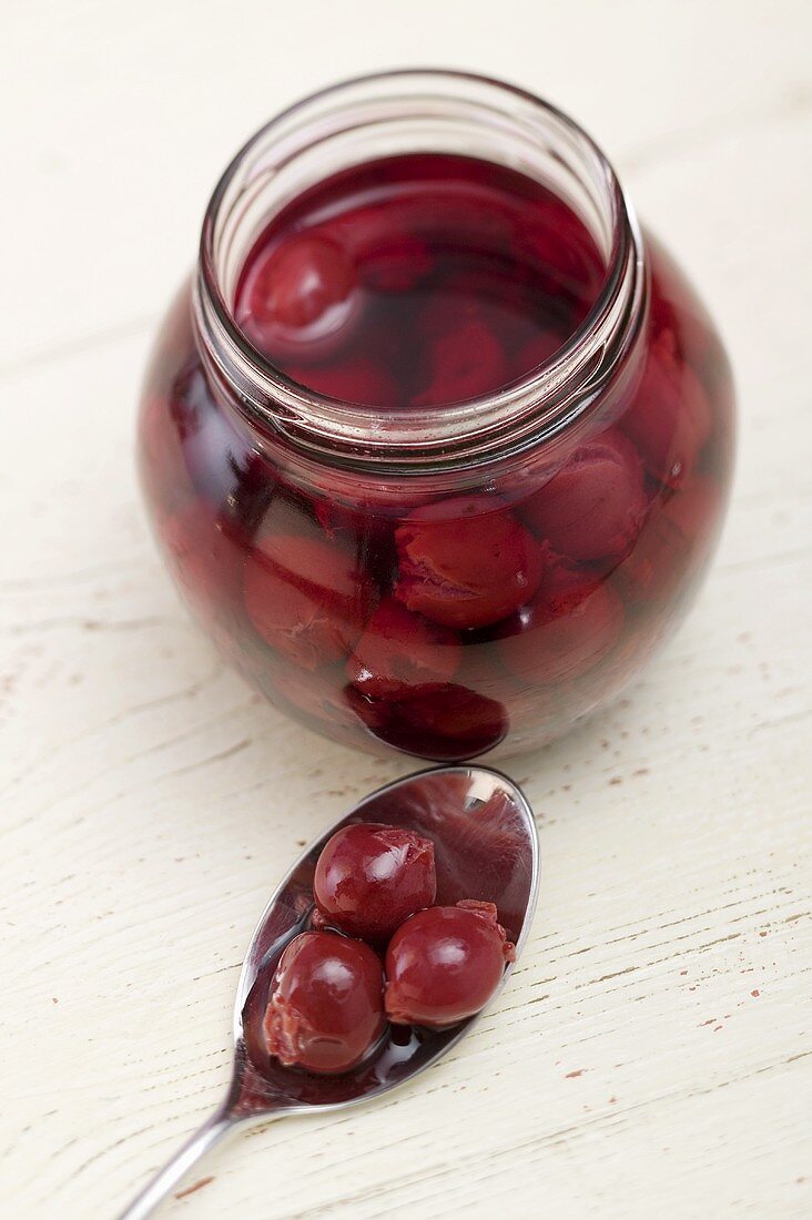 Cherry compote in jar and on spoon