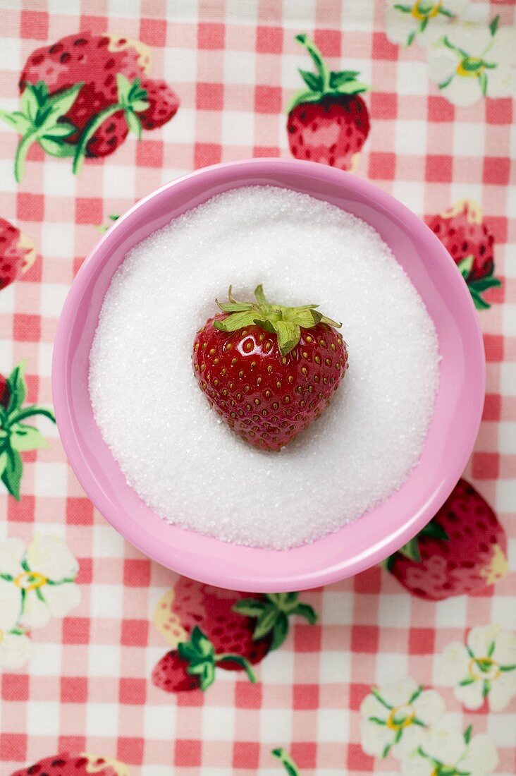 Erdbeere in einem Schälchen Zucker