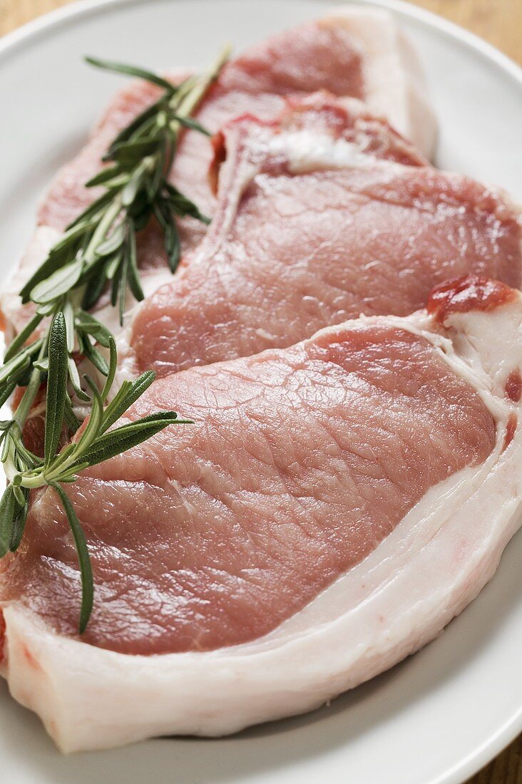 Raw pork chops with rosemary
