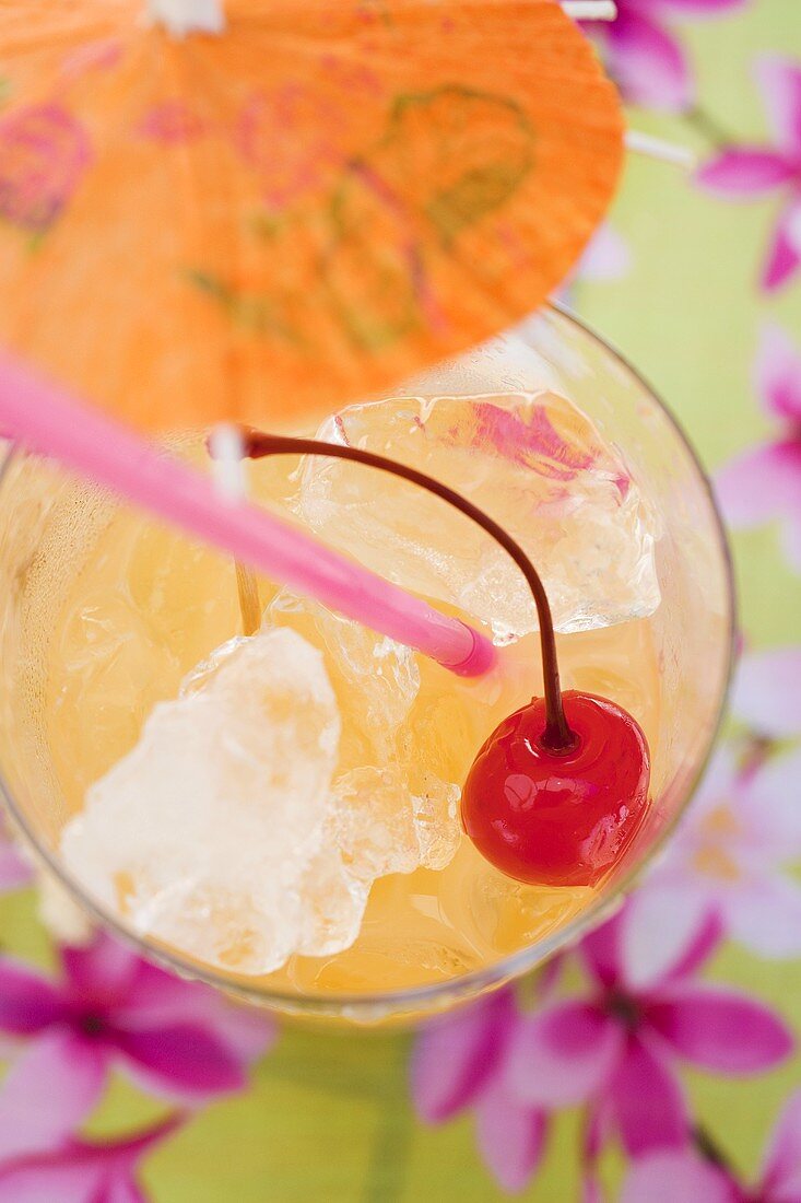 Fruchtiger Cocktail mit Eiswürfeln und Cocktailkirsche
