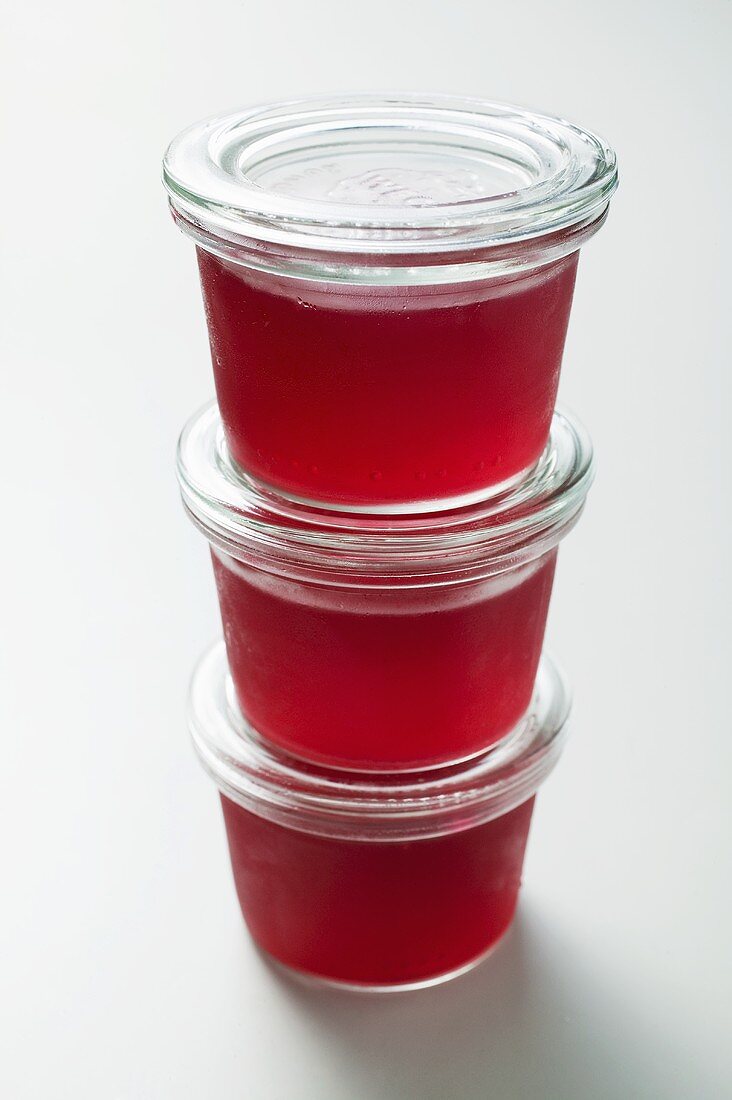 Three jars of redcurrant jelly in a pile