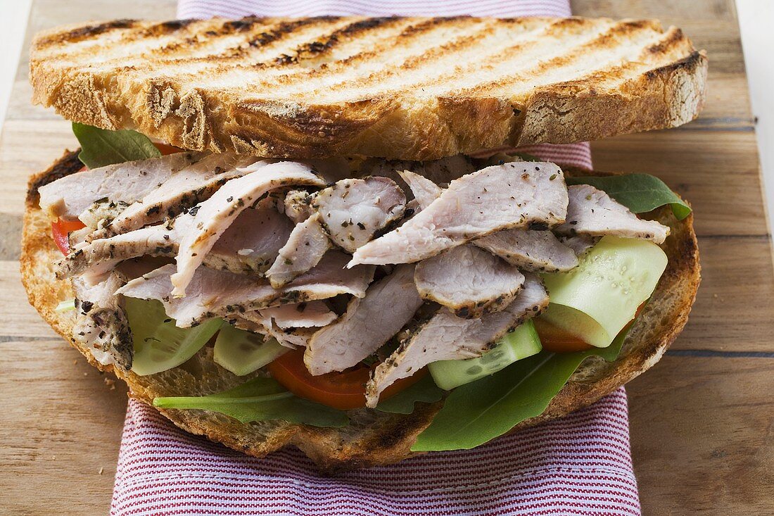 Toasted bread topped with pork and salad
