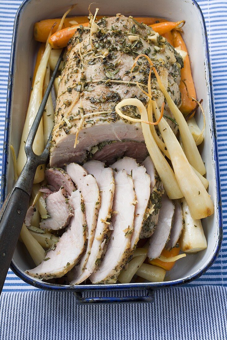 Rolled pork roast with herbs, carrots, parsley roots