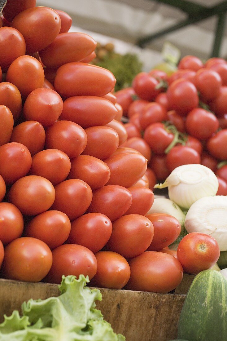 A heap of plum tomatoes in a crate at a market