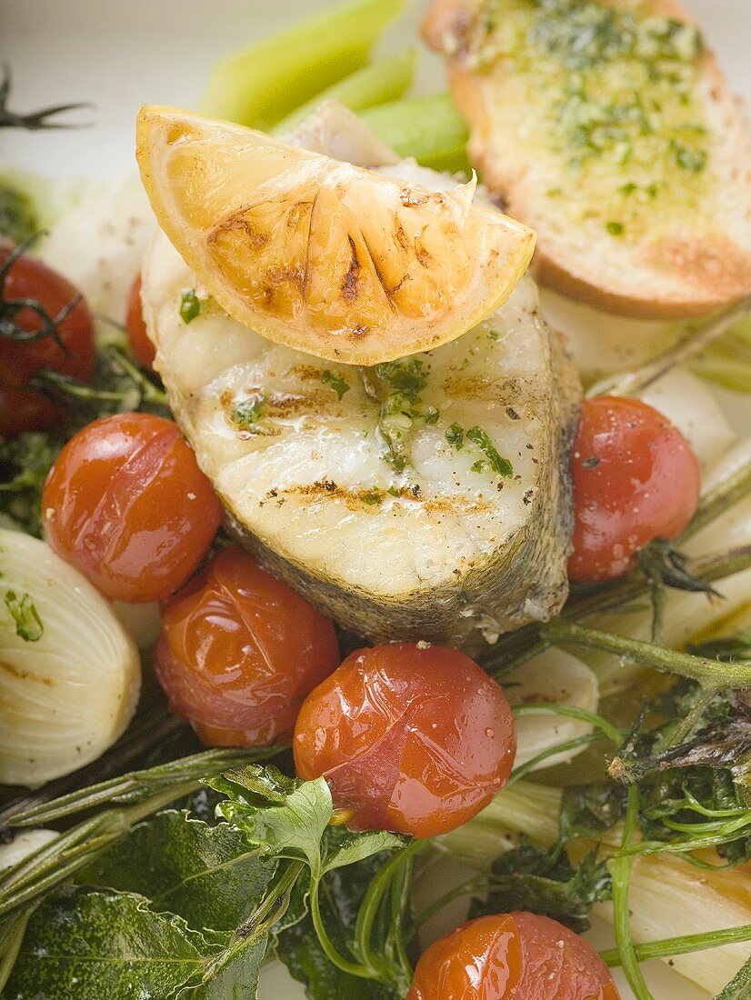 Sea bass cutlet with lemon on roasted vegetables