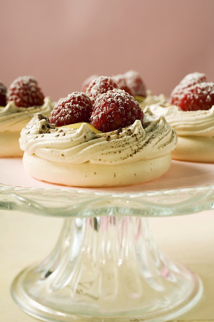 Meringue shells with raspberries and icing sugar