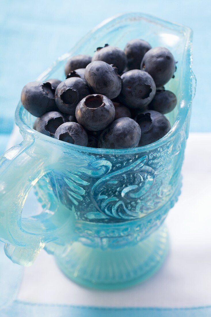 Fresh blueberries in light blue glass jug