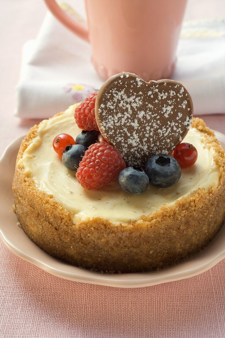 Käsekuchen mit frischen Beeren und Schokoladenherz