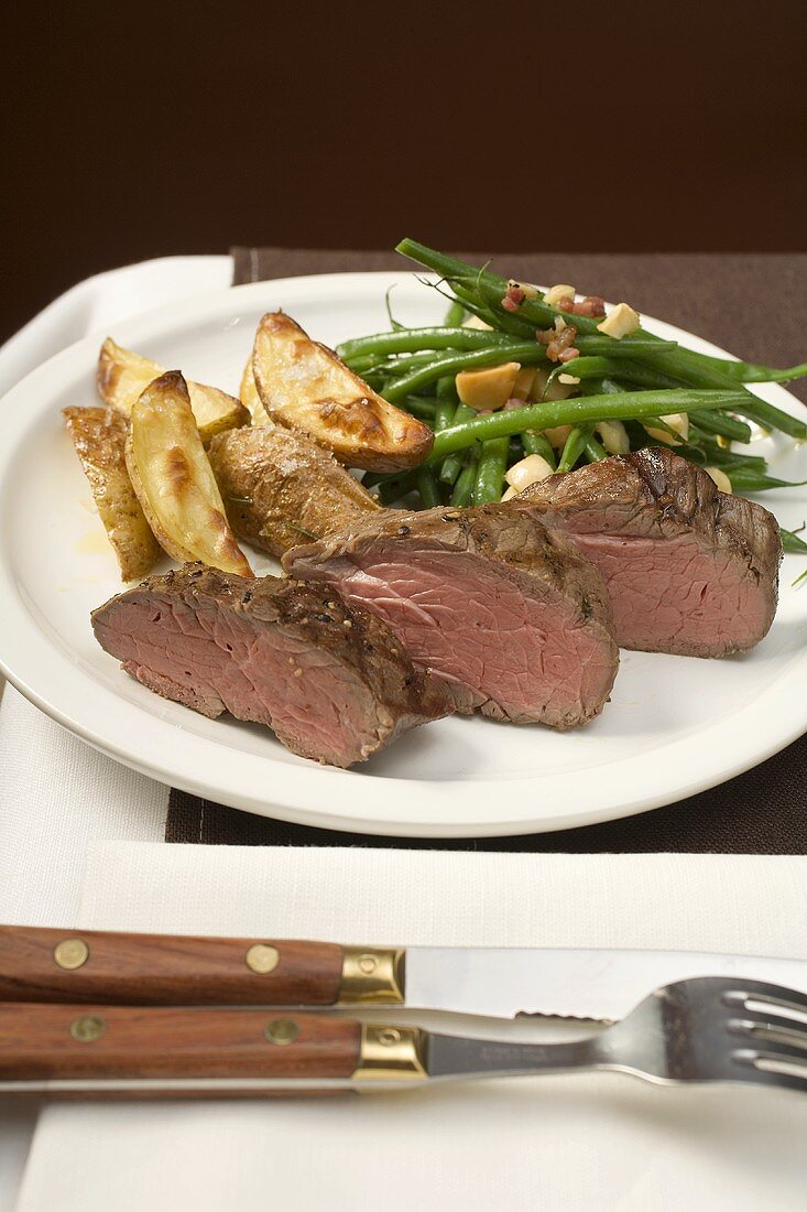 Beef steak with potato wedges, beans & bacon