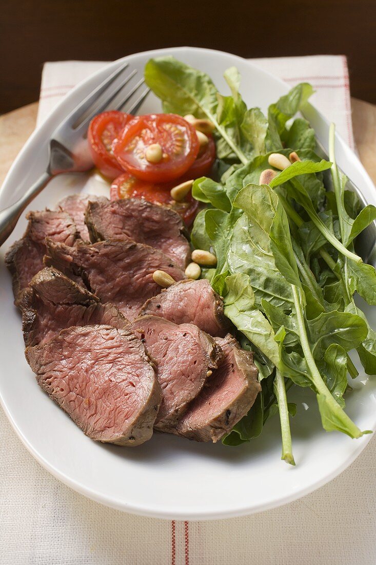 Beef with spinach, pine nuts and tomatoes