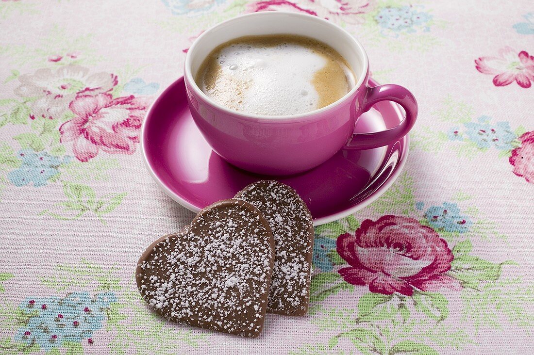 Cup of cappuccino with two chocolate hearts
