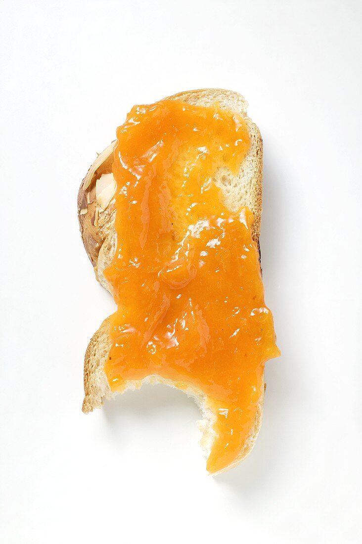 Slice of bread plait with apricot jam, a bite taken