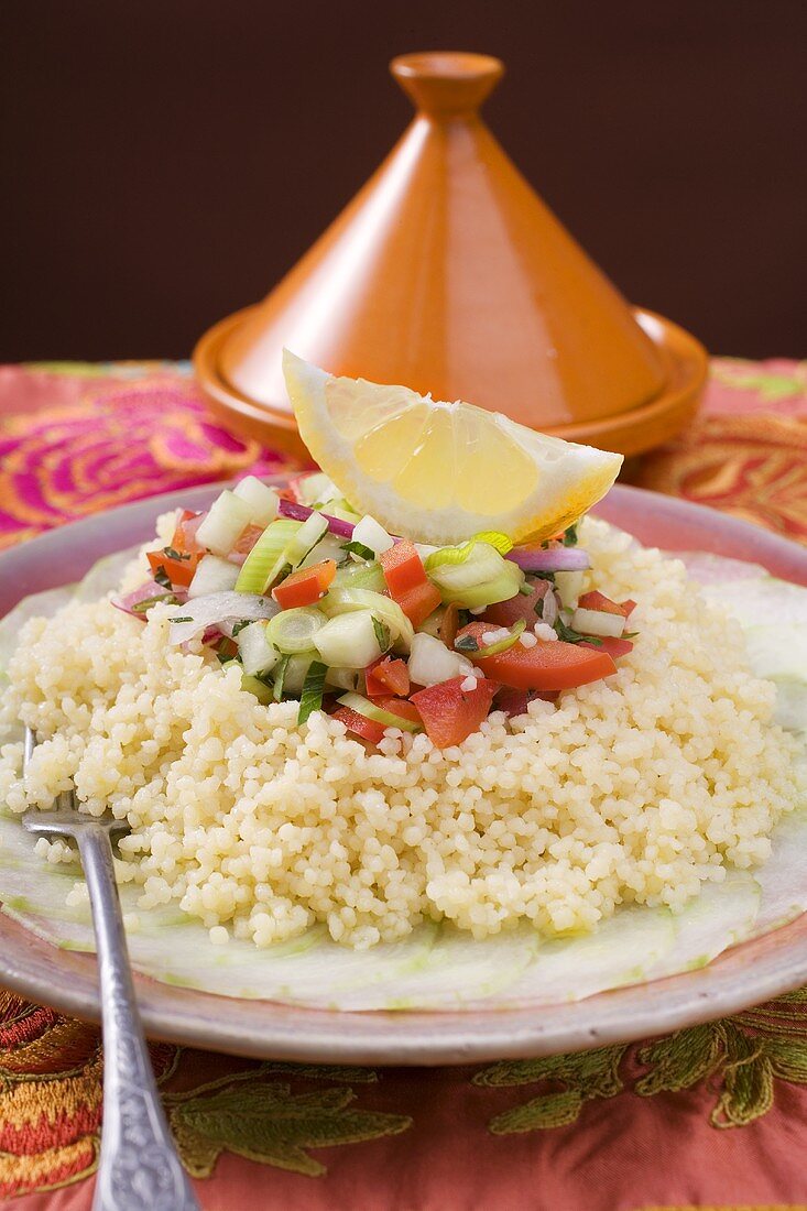 Couscous on cucumber slices with onions, leeks and peppers