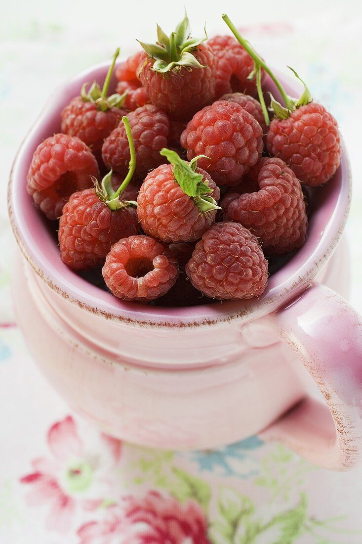 Frische Himbeeren im rosa Krug