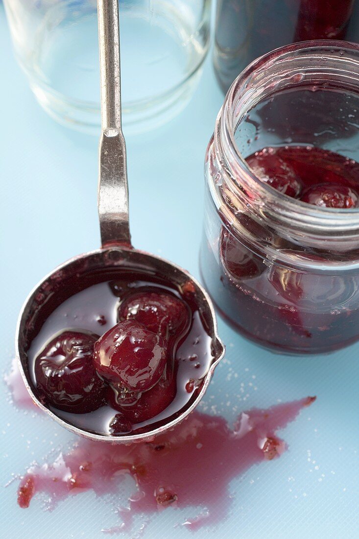 Ladling cherry jam into jars