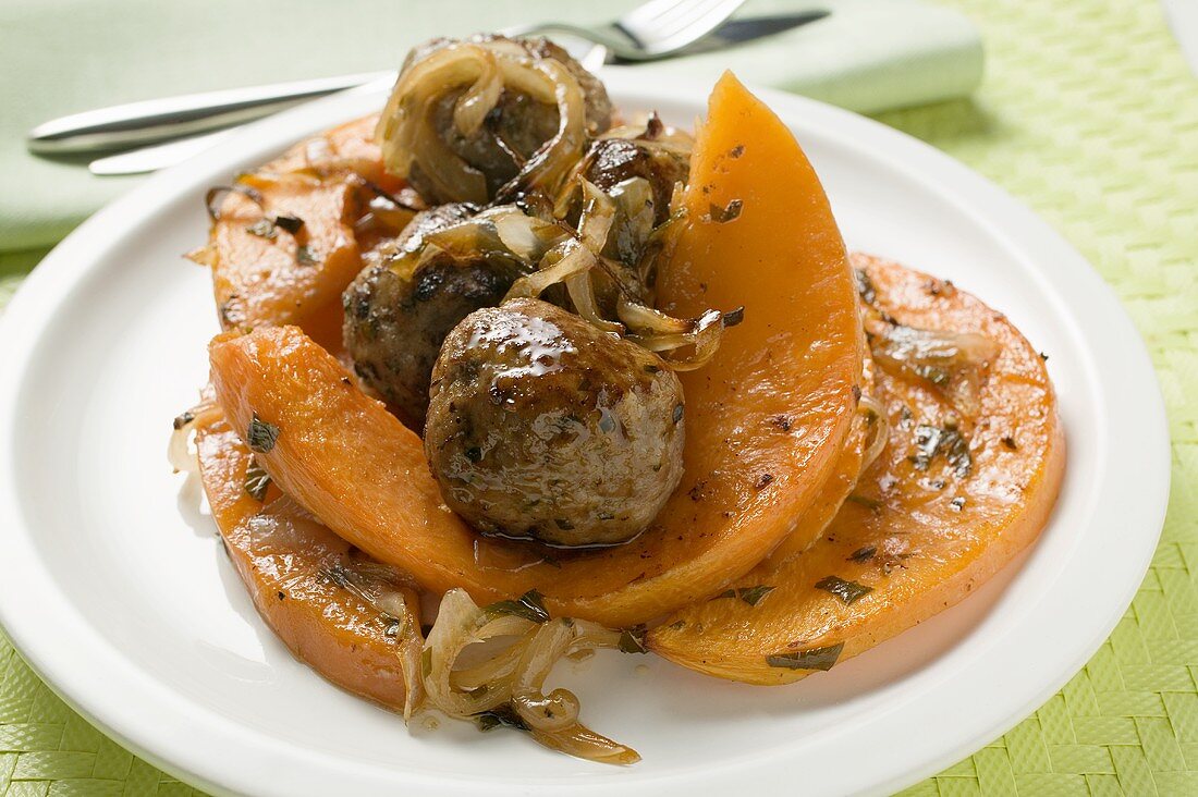Meatballs with roasted pumpkin wedges on plate