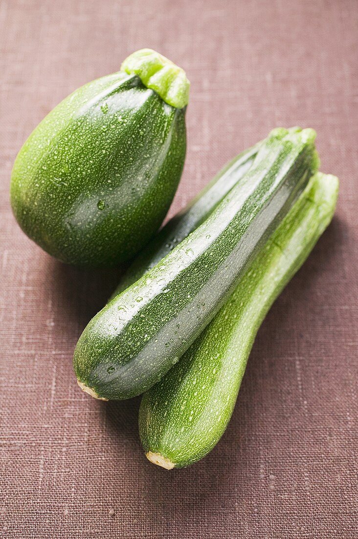 Round and long courgettes with drops of water