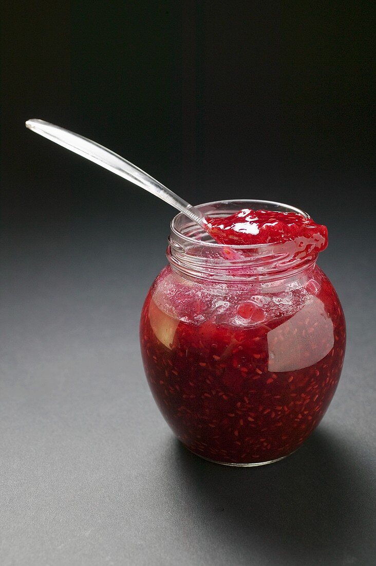 Raspberry jam in jar with spoon