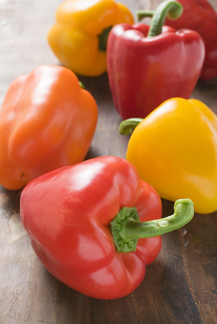 Yellow, orange and red peppers on wooden background