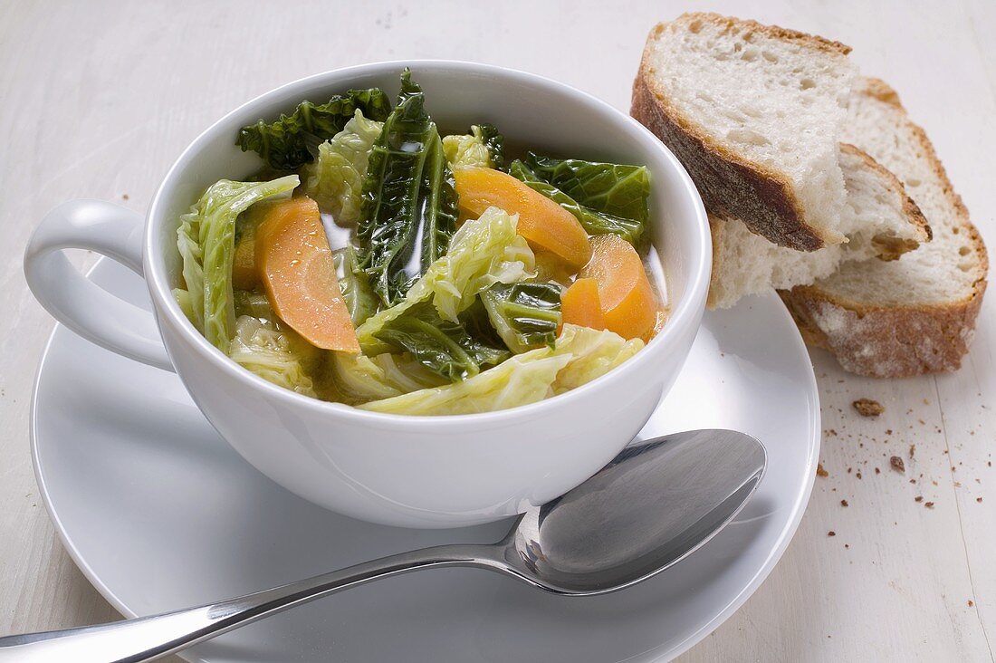 Savoy and carrot stew in soup cup, slices of bread